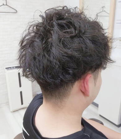 自然なカールが特徴のショートヘアの男性、後ろ姿。